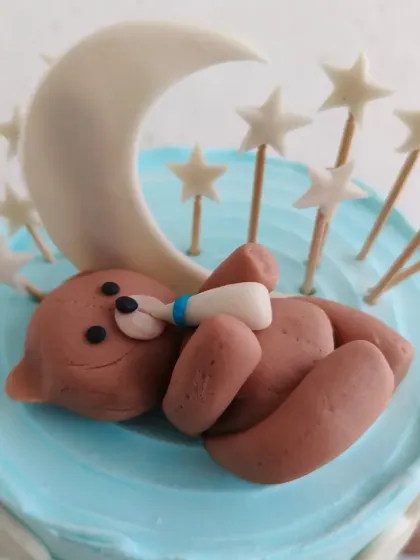 A close-up of the adorable hand-molded fondant teddy bear sleeping on the moon.