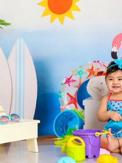 A happy beach baby playing with her bucket and spade. The bright colors and her joyful expression make this a perfect summer photo.