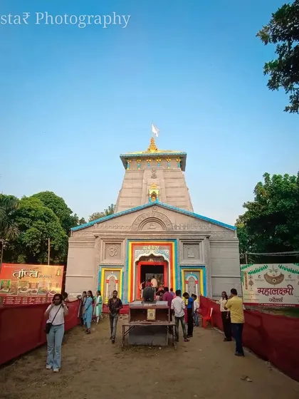 A daytime, ground-level shot of the Kedarnath-themed pandal. This shows how the structure looks in natural light, capturing the colors and the people visiting during the day.