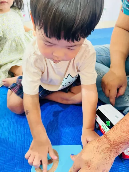 A teacher assists a child in tracing a number with his finger, showing our supportive and individualized approach to learning.