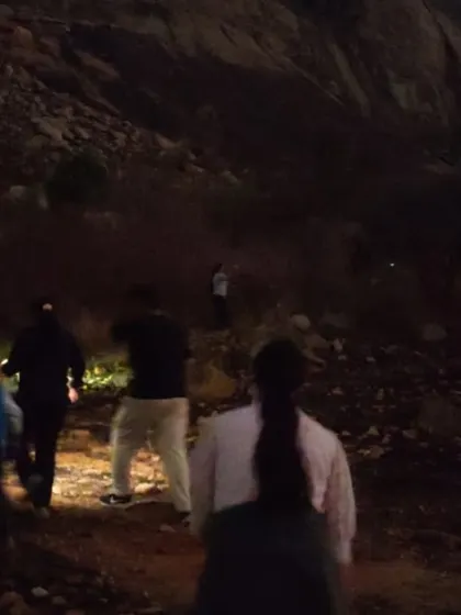 The night trek begins. Our group making their way up the hill in the dark, guided by torchlight.