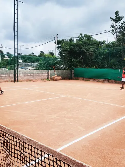 Junior players engaged in a competitive doubles match during an AITA U-14 tournament, showing the dynamic play and teamwork fostered at my events.