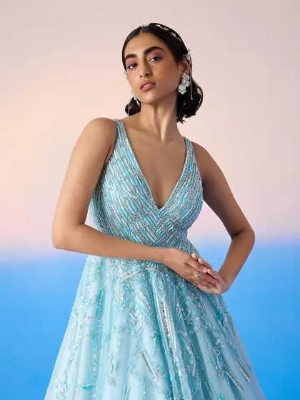 A close-up of the embellished bodice of the blue ballgown, revealing the detailed beadwork and flattering V-neckline.