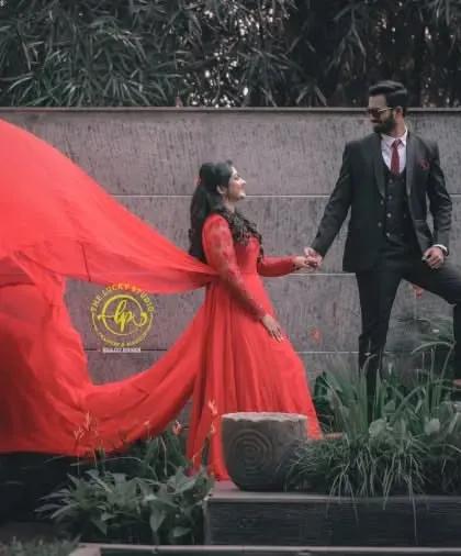 A modern, stylish pose showing the couple's connection. The red gown's trail adds a dynamic element to the composition.