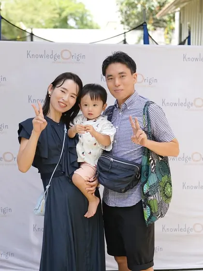 A happy family smiles for a photo at one of our community events, showcasing our diverse and international family base.