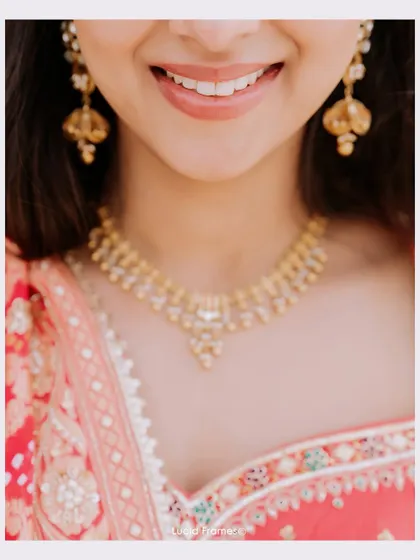 A close-up on the bride's smile and her beautiful necklace, a simple yet captivating portrait.