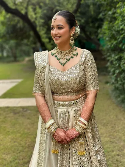 A dreamy, sun-kissed outdoor shot. The soft glam makeup with a clean bun and beautiful jewelry creates a look of pure elegance.