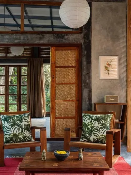 The living space in the Jalakara villa, showing the transition to the bedroom through sliding woven panels.