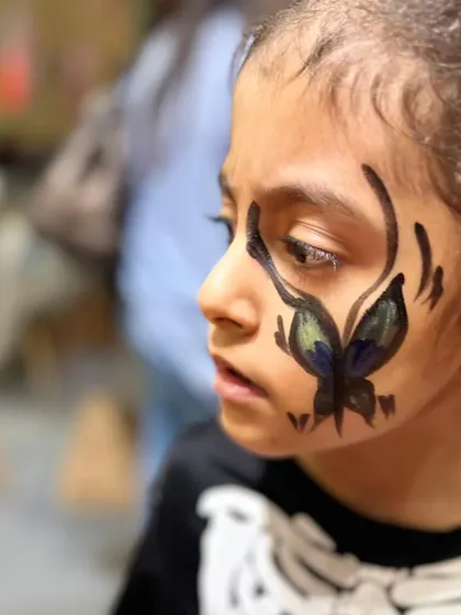 A delicate butterfly design painted on a child's cheek. Our face painters can create all sorts of designs, from spooky Halloween looks to beautiful and whimsical art.