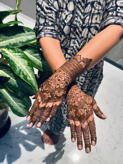 A different pose showing the flow of the mandala design from the back of the hand down to the fingertips, with each line carefully placed.