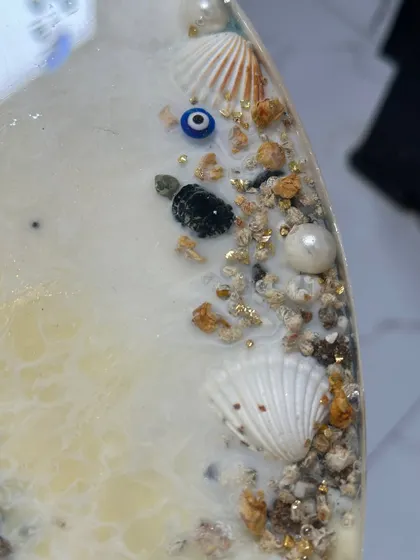 I always add personal touches, like this tiny turtle charm and a nazar battu, hidden among the shells and sand on the beach-themed table. It’s these little details that make a piece special.