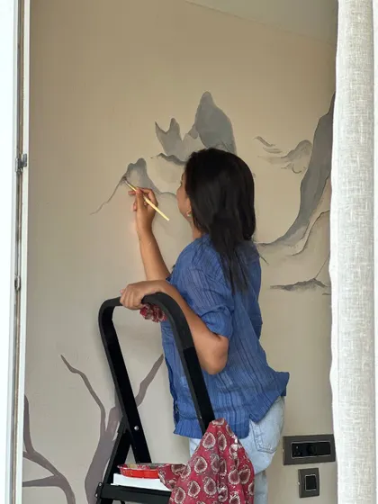 A quiet moment on a stepladder, painting a mountain mural. Art and life move in a quiet rhythm, and in the simplicity of lines and colors, we find truths too soft for words.