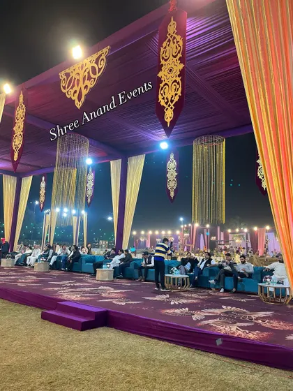 A luxurious lounge area with deep purple carpeting, teal sofas, and ornate gold hanging decor, creating a rich and royal ambiance.