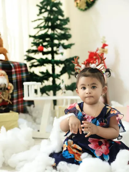 A sweet portrait of a little girl in a floral dress amidst our Christmas decorations. Her curious expression is simply adorable.