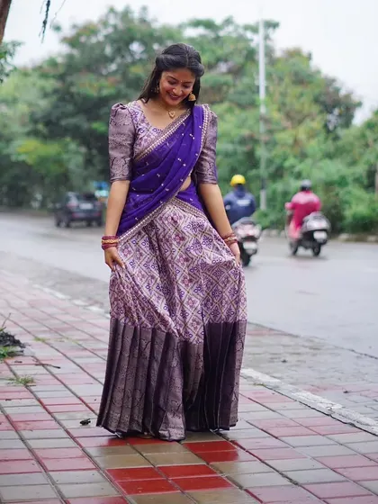 Even on a rainy day, this purple half saree brightens up the scene. It's a versatile outfit for all seasons.
