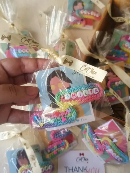 Packaging our name clips as birthday return favors. Each pair is wrapped with a ribbon, making them a delightful gift for little guests.