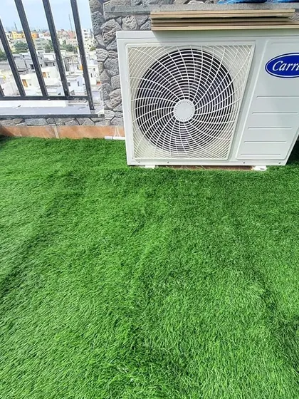 We expertly cut and fit the artificial grass around obstacles like this outdoor AC unit, ensuring a seamless and professional finish.