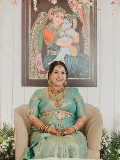Seated in front of a painting of a mother and child, this portrait is especially poignant. Her makeup is soft and glowing, reflecting the beauty of motherhood.