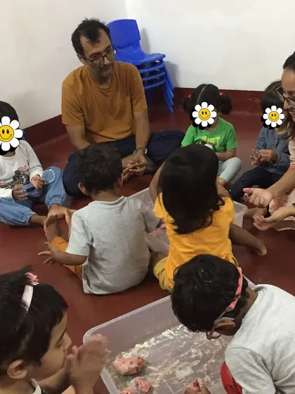A father joins in a hands-on activity with the children. We love welcoming parents into our classrooms to share their skills and passions, enriching the learning experience for everyone.