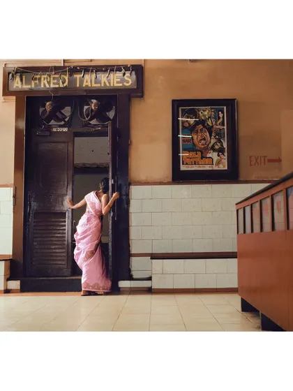 Peeking into the theater, this shot captures a moment of curiosity and wonder. The setting of Alfred Talkies in Mumbai was crucial for building this film-centric narrative.