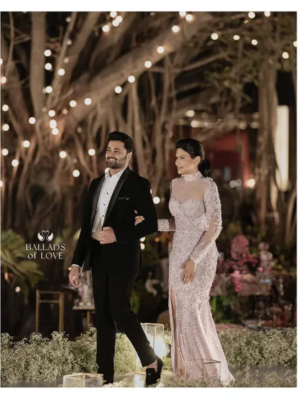 Creating a romantic and cozy atmosphere with soft, delicate lighting. The couple is surrounded by dozens of candles, casting a warm glow that is perfect for intimate reception photos.