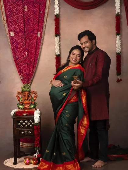 A beautiful couple's portrait in a traditional South Indian style. The green and red saree is vibrant and stunning.