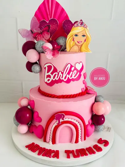 A vibrant two-tier Barbie dream cake, with a rainbow, hearts, and plenty of pink and glitter.