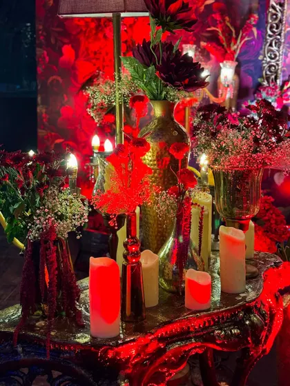 This masquerade-themed party was drenched in dramatic red lighting, with intricate floral centerpieces, candelabras, and even a mirrored mannequin adding to the mysterious and glamorous vibe.