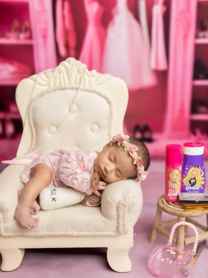 A Barbie-themed dream! This little one is sleeping on a miniature armchair in a pink room, ready for a day of dress-up.