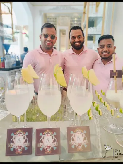 Our team presenting freshly made cocktails in elegant wine glasses, garnished with melon slices. The personalized coasters add another layer of custom branding to the experience.
