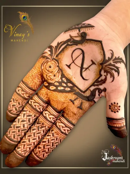 A groom's mehndi set featuring a dancing couple on one hand and his initial 'A' in a crest on the other.