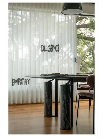 Details from our studio. The sheer curtains with our core values, "EMPATHY" and "ORIGINALITY," serve as a constant reminder of what drives our work. The marble-legged table is where many of our designs take shape.