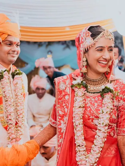 A candid, happy moment as the couple walks together during their Pheras, sharing a laugh.