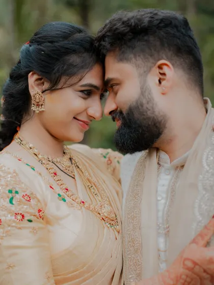 An intimate portrait of the couple, their foreheads touching, in a beautiful natural setting.