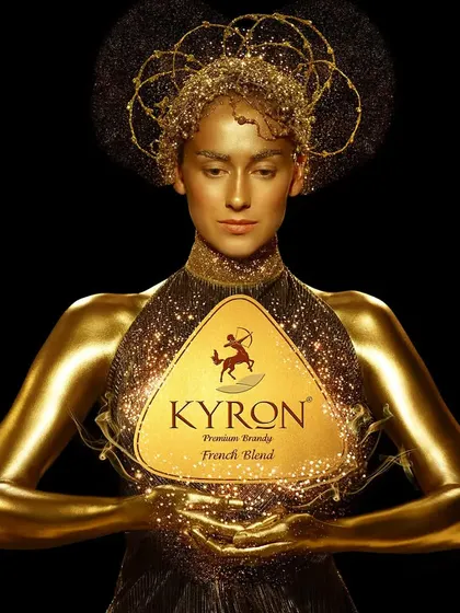 A conceptual portrait for Kyron Brandy, where the model is transformed into a golden, goddess-like figure. The image uses light and texture to create a feeling of magic and luxury.