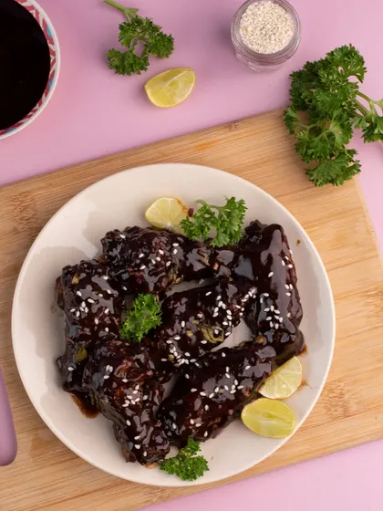 These sticky BBQ chicken wings are styled to look messy in the most delicious way. We focused on the glossy sauce and fresh parsley garnish to make them look extra tempting for a food delivery platform.