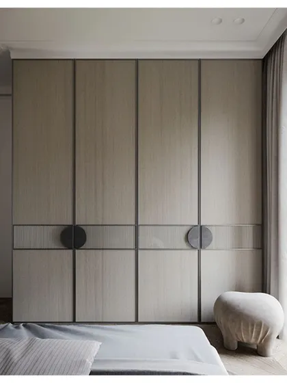 A close-up of a custom-designed wardrobe with a minimalist aesthetic. The clean lines, neutral color, and unique circular handles showcase our attention to detail in furniture design.