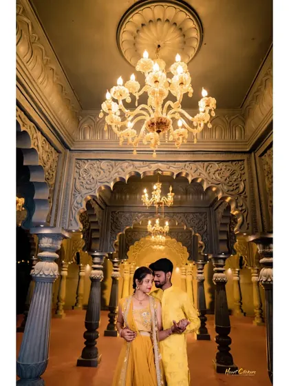 A stunning pre-wedding portrait in a grand hall. The symmetry of the arches and the warm glow of the chandeliers create a majestic scene.
