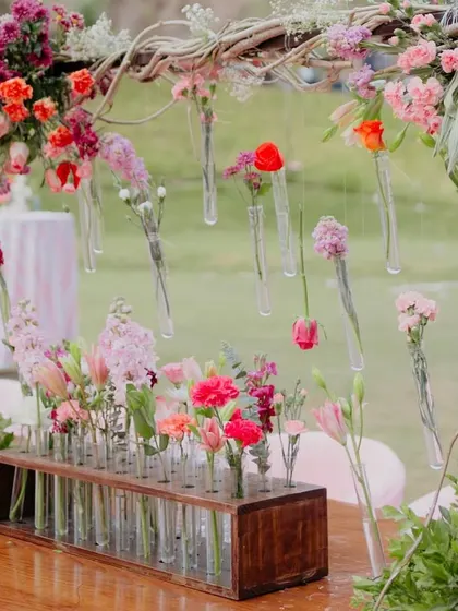 It's all in the details. We used hanging single-stem flowers in test tubes to create a delicate, whimsical floral installation that added a unique touch to the decor.