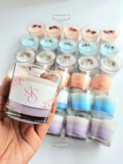 A close-up of a personalized votive candle from Sandra's order, showcasing the custom 'AS' wedding logo sticker.