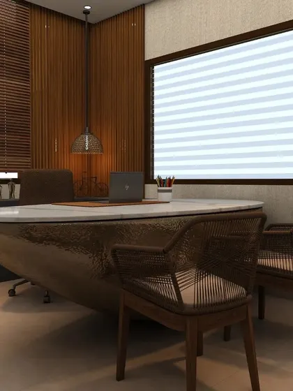 This director's cabin for Interblocco was designed to be a statement of leadership. The centerpiece is a unique boat-shaped desk with a hammered metallic finish, paired with natural rattan chairs and warm wood paneling for a sophisticated look.