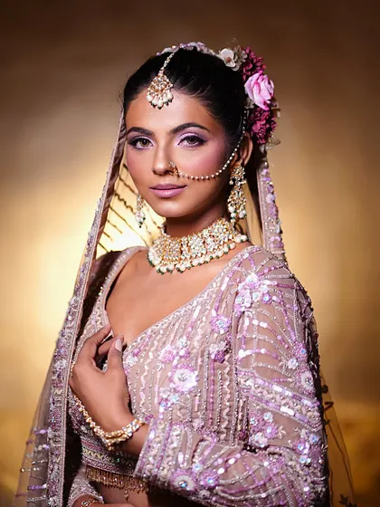 Meet a stunning bride, brought to life with elegant makeup. This look in a pastel purple lehenga features beautiful pink and purple eyeshadow and a soft, glowing complexion.