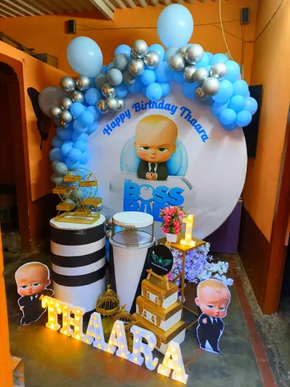 This Boss Baby setup for a first birthday uses a circular backdrop and themed plinths for a compact yet impactful decoration.