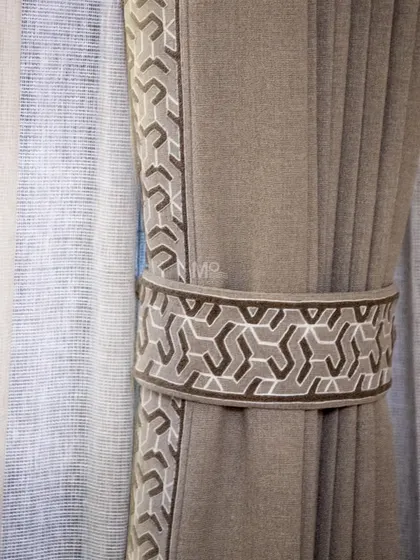 Detail of a custom curtain tie-back with a modern geometric pattern. This small touch adds a layer of sophistication and demonstrates our commitment to personalized design.