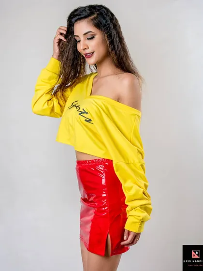 A side-profile shot from the "I'm Lovin' It" series. The model's smile and the bright colors of her outfit create a happy and energetic vibe in this studio fashion shoot.