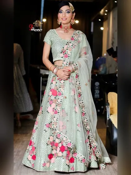 A client looking radiant in a mint green lehenga with colorful floral embroidery. This is a wonderful rental option for a spring or summer wedding event.