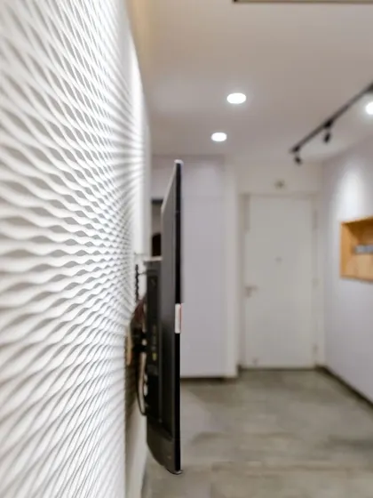 A close-up of the white wave board used on the TV wall, a detail that adds subtle texture and visual interest.