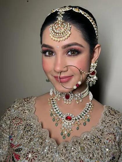 The complete bridal look with the nath (nose ring). Every detail, from the makeup to the jewelry, is carefully considered to create a cohesive and stunning appearance.