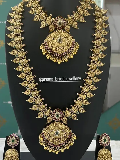This haaram and choker set features intricate peacock and floral motifs with red and green stones.