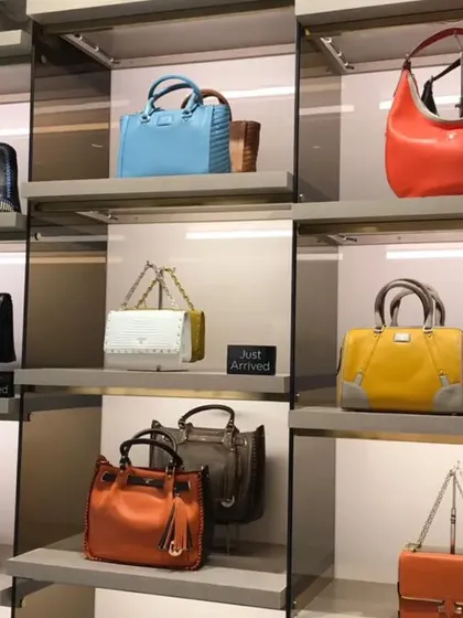 A close-up of the illuminated glass display boxes used to showcase premium handbags as feature items.